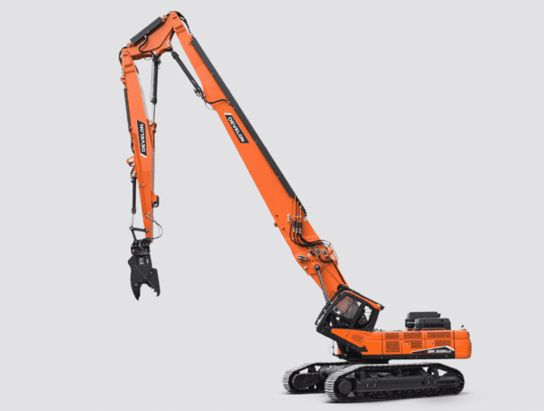 Pelle de démolition sur chenilles Develon DX530DM équipée d’un bras télescopique long et d’un grappin hydraulique.